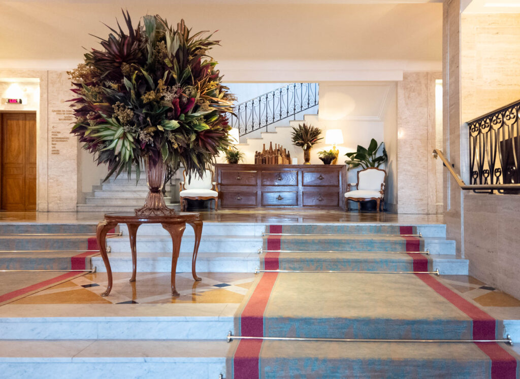 Elegant lobby with grand floral arrangement and marble staircase at Belmond Copacabana Palace, a luxury hotel in Rio de Janeiro ©Stephanie Dosch | theViatrix Luxury Travel